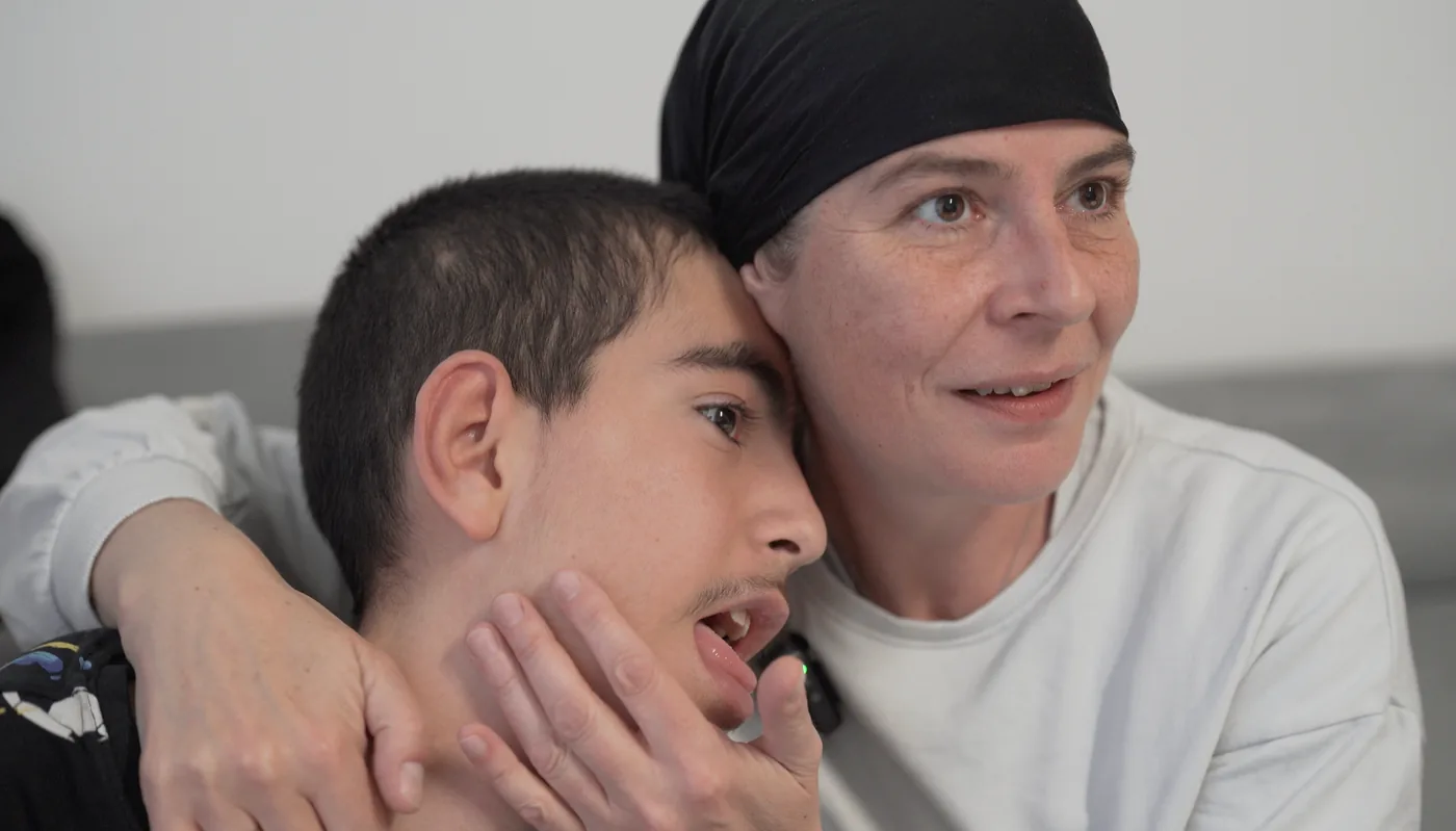 Mutter umarmt ihren Sohn zu Hause