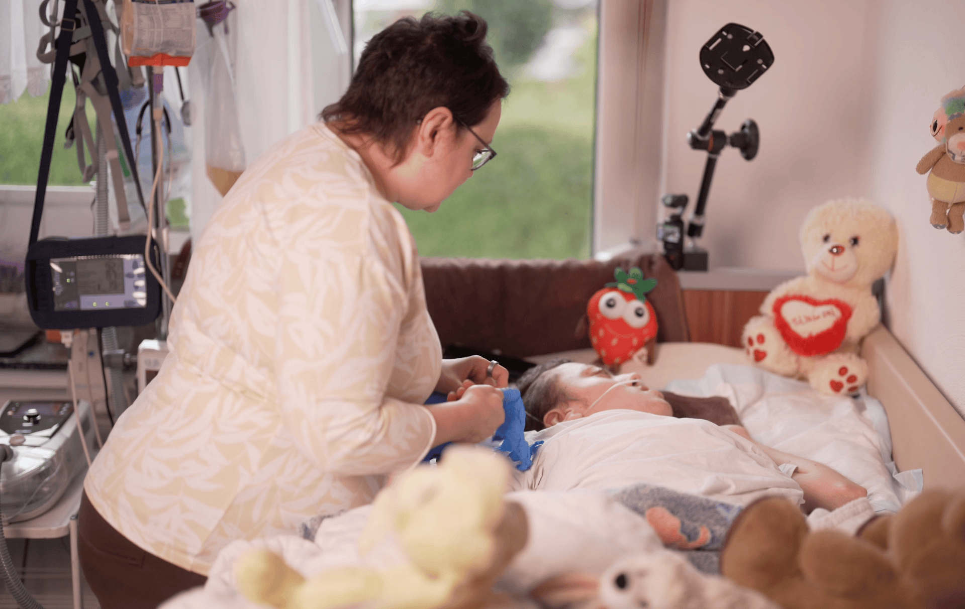 Pflegefachkraft versorgt Kind liebevoll im Kinderzimmer – häusliche Intensivpflege